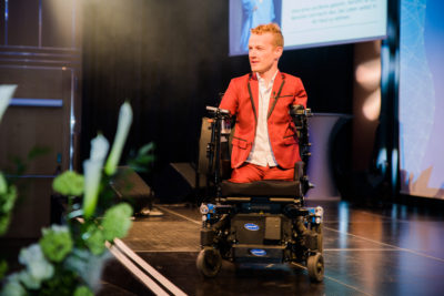 Janis McDavid bewegt sich auf der Bühne mit seinem Elektro-Rollstuhl