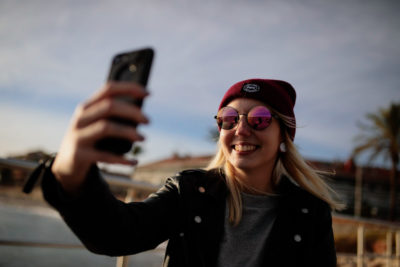 Eine junge Frau macht mit ihrem Handy ein Selfie