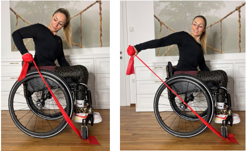 Eine junge Frau sitzt im Rollstuhl. Sie hat ein Theraband unter ihr Vorderrad geklemmt und macht Übungen für ihre Arme.